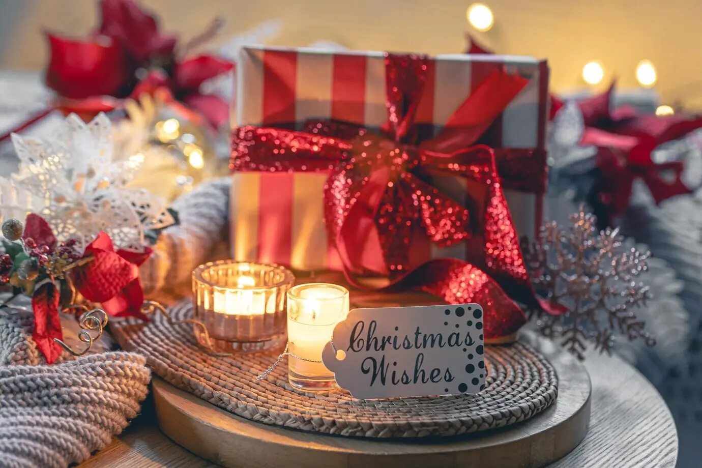 Weihnachtskomposition mit Geschenkbox, Kerzen und gestricktem Element